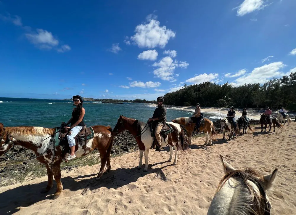 Prevail team members horseback riding on the beach